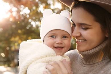 Photo of Happy mother with her baby daughter outdoors on autumn day, closeup