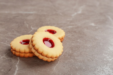 Photo of Traditional Christmas Linzer cookies with sweet jam on grey background