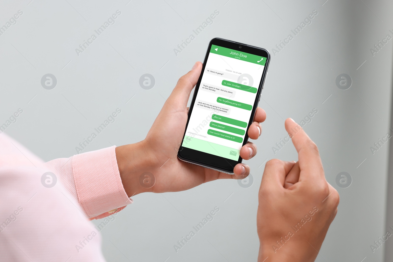 Image of Man texting with friend using messaging application on smartphone against light grey background, closeup