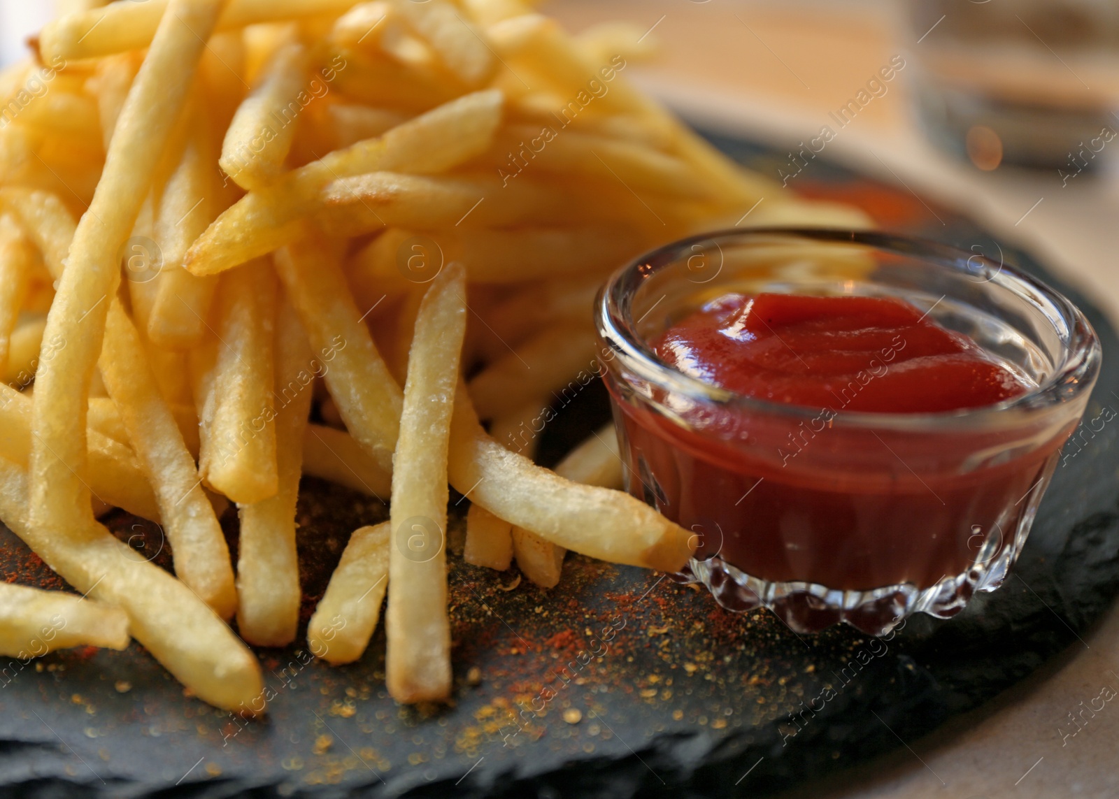 Photo of Tasty French fries with red sauce served on table in cafe, closeup