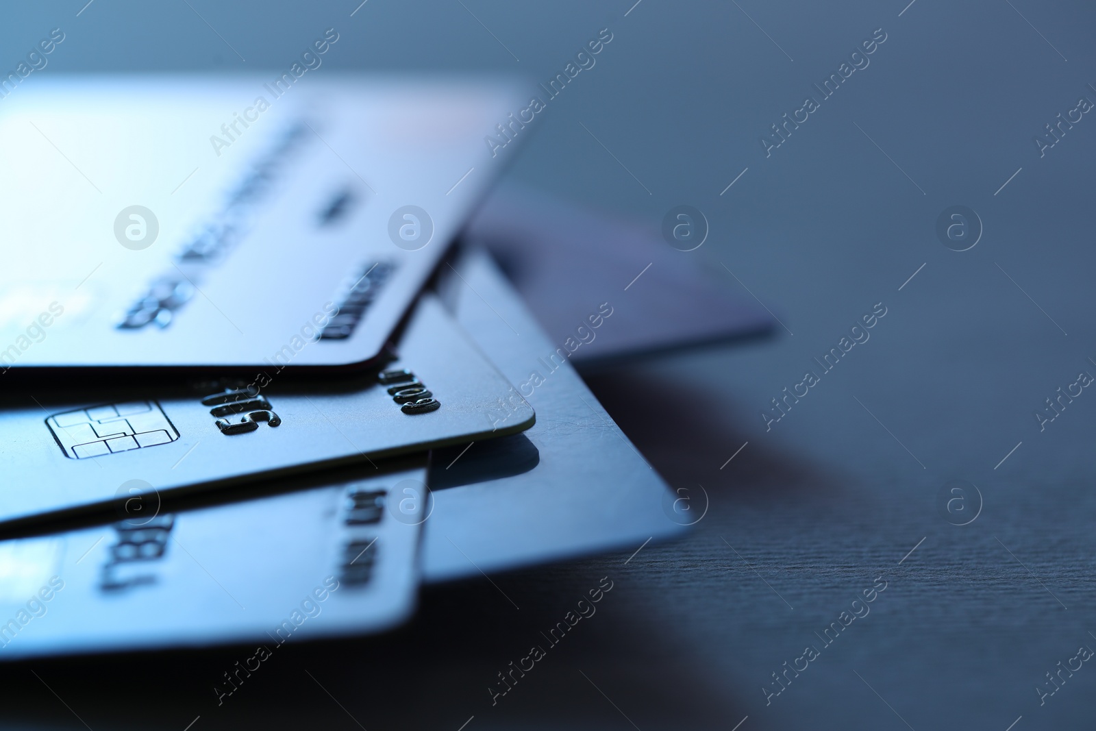 Photo of Many credit cards on dark background, closeup