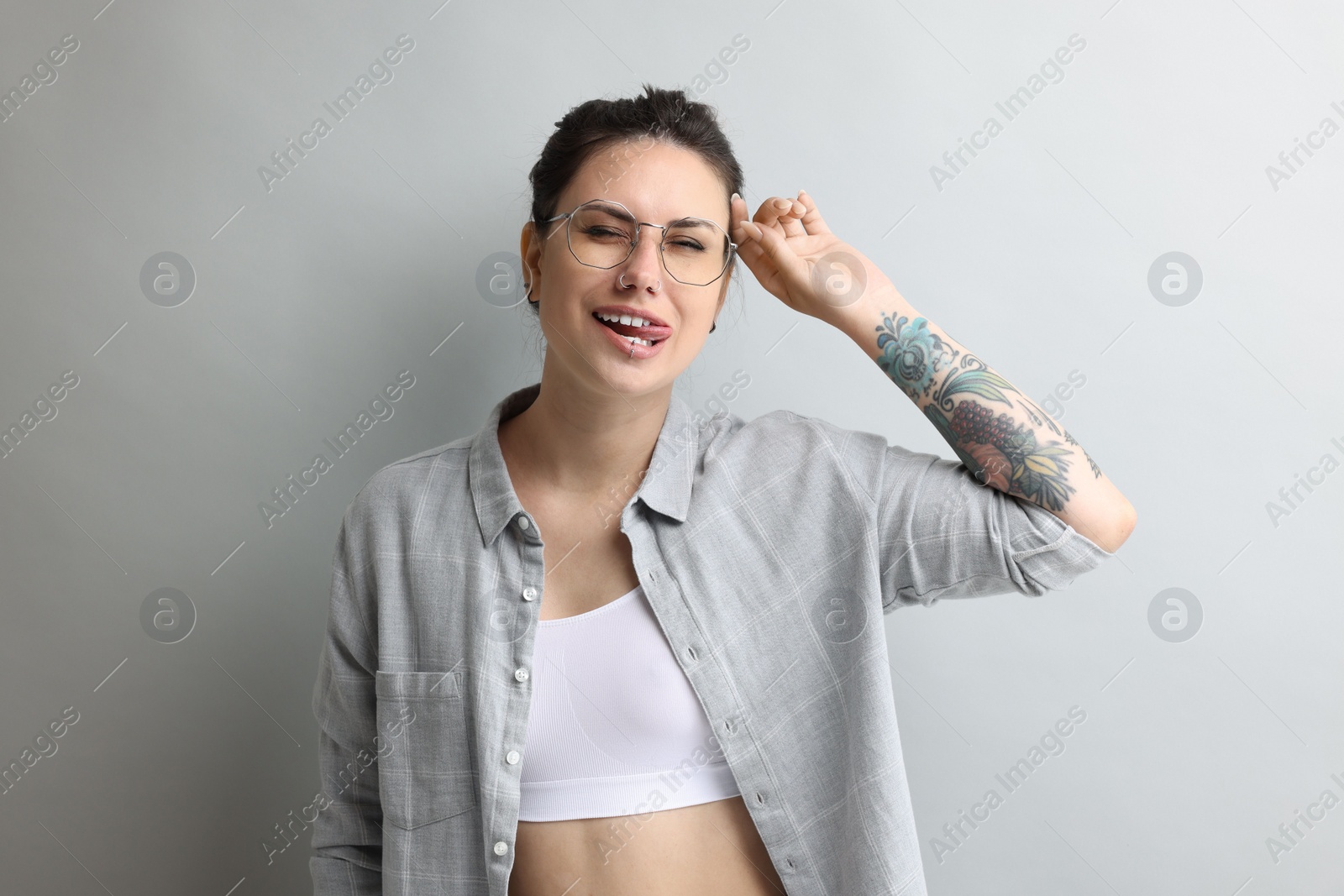 Photo of Portrait of beautiful tattooed woman on gray background