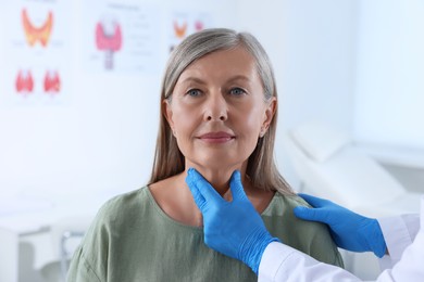 Endocrinologist examining thyroid gland of patient at hospital, closeup