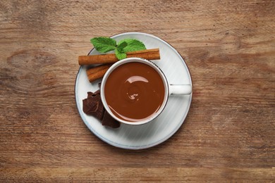 Photo of Yummy hot chocolate in cup on wooden table, top view