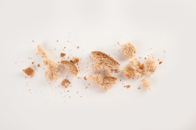 Scattered bread crumbs on white background, top view