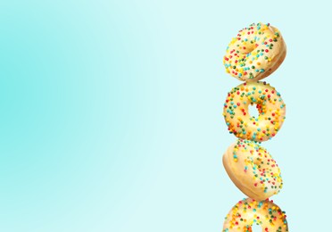 Tasty donuts with sprinkles on light blue gradient background, space for text