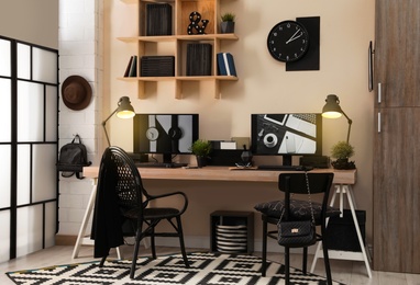 Photo of Stylish workplace interior with computers on table