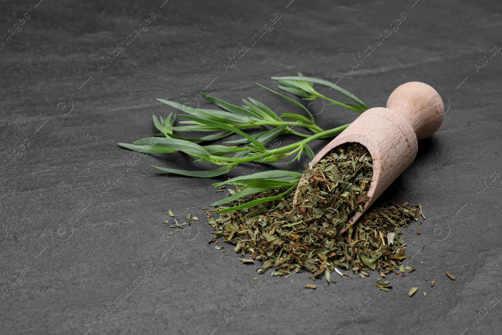 Photo of Dry and fresh tarragon on black textured table, space for text