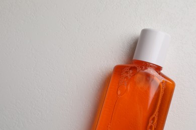 Photo of Fresh mouthwash in bottle on white background, top view. Space for text