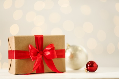 Christmas gift on wooden table against blurred lights