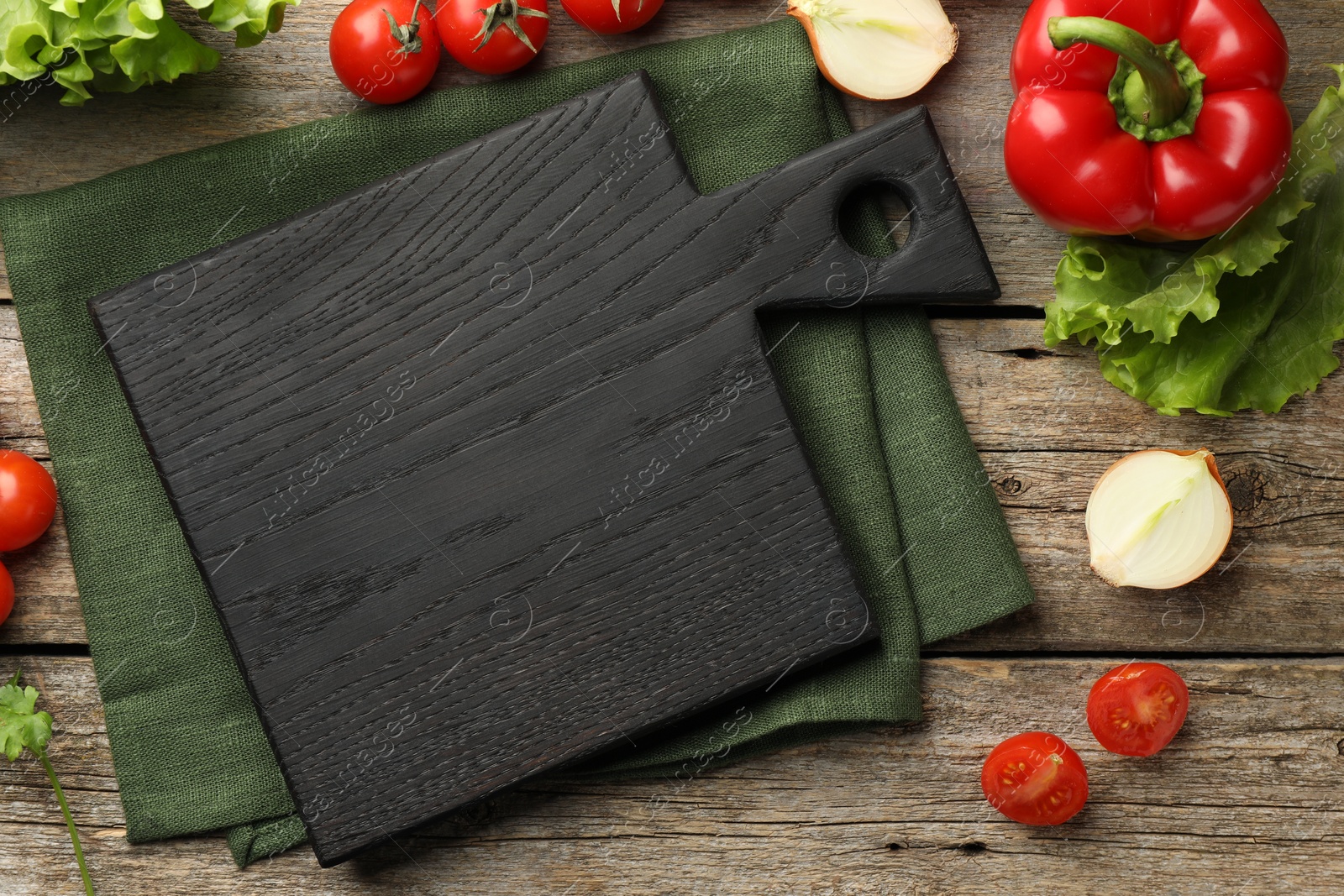 Photo of Flat lay composition with black cutting board and products on wooden table