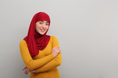 Portrait of Muslim woman in hijab on light gray background, space for text