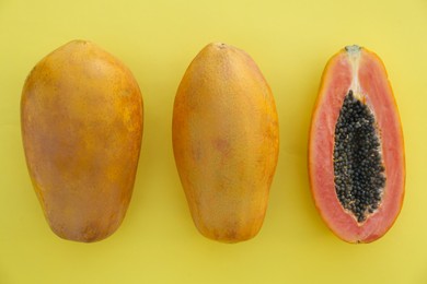 Fresh ripe cut and whole papaya fruits on light green background, flat lay