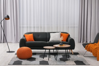 Photo of Comfortable sofa, floor lamp and coffee table in stylish room. Interior design