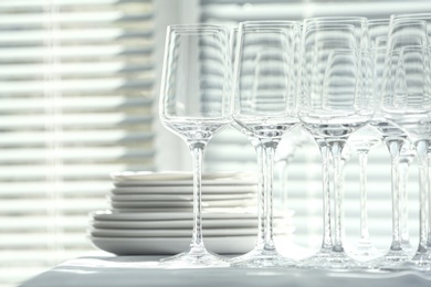 Photo of Set of empty wine glasses and dishware on table indoors