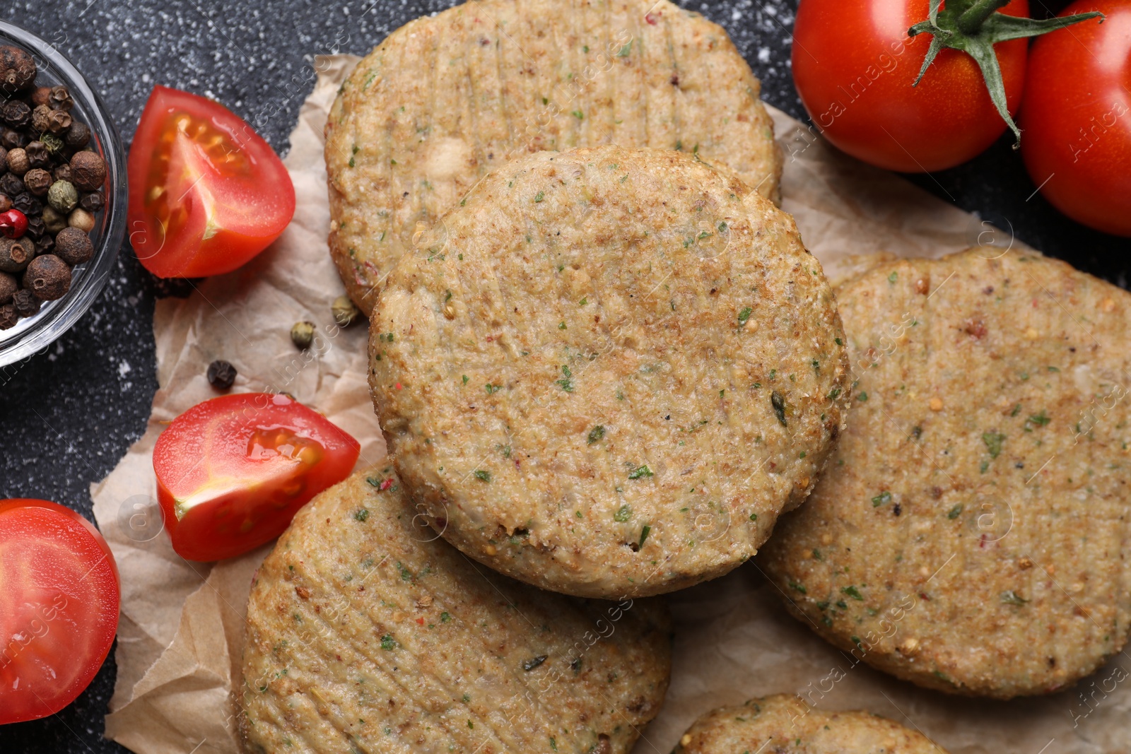 Photo of Tasty vegan cutlets and products on grey table, flat lay