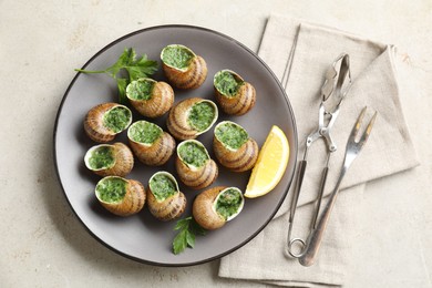 Photo of Delicious cooked snails served on light table, flat lay