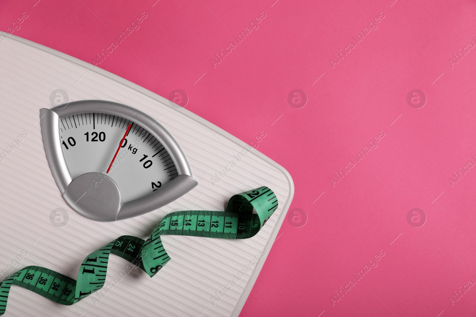 Photo of Weight loss concept. Scales and measuring tape on pink background, top view. Space for text