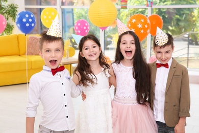 Photo of Cute little children at birthday party indoors