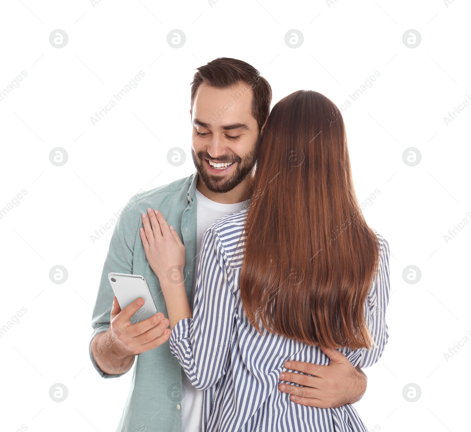 Photo of Man interested in smartphone while hugging his girlfriend on white background. Relationship problems