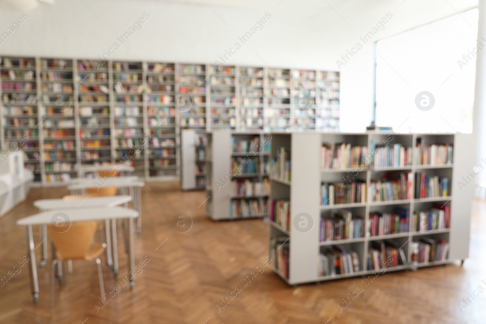 Photo of Blurred view of library interior with bookcases and tables