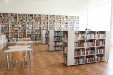 Photo of Blurred view of library interior with bookcases and tables