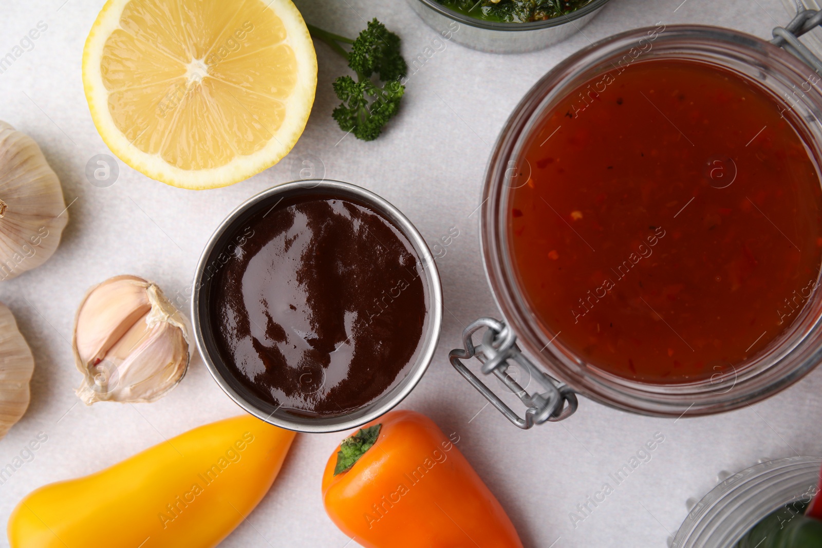 Photo of Different marinades and products on light table, flat lay