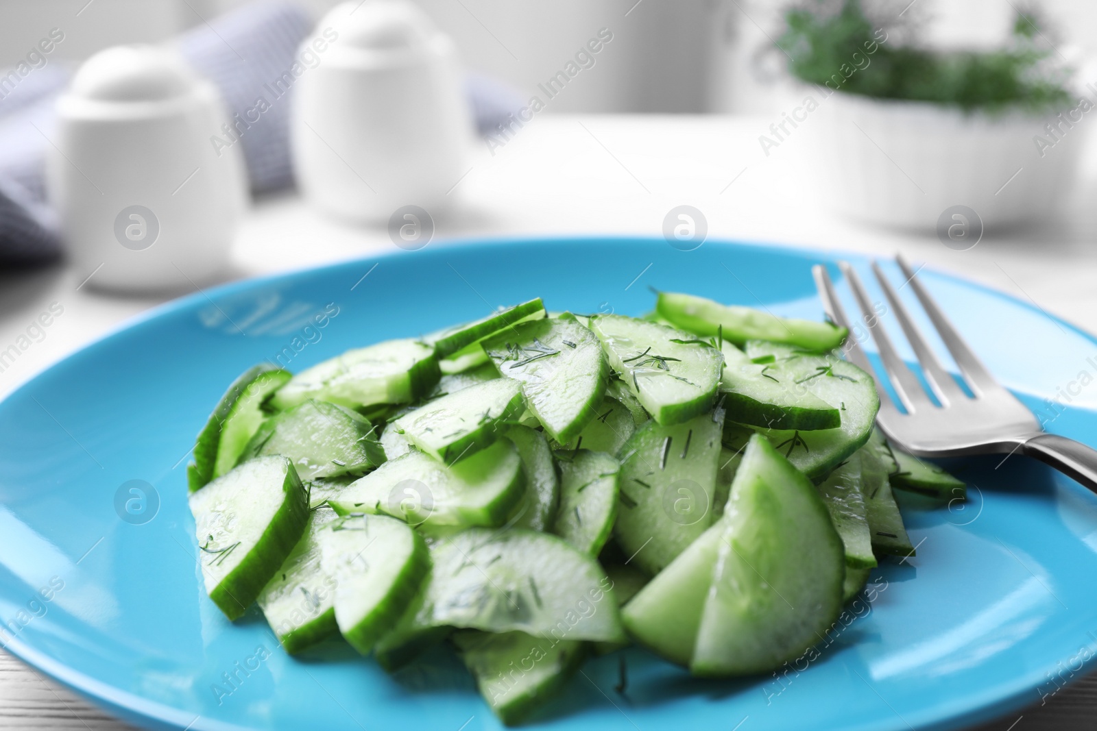 Photo of Plate of tasty cucumber salad on table, closeup