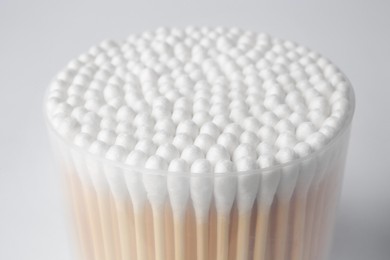 Photo of Open container with cotton buds on white background, closeup