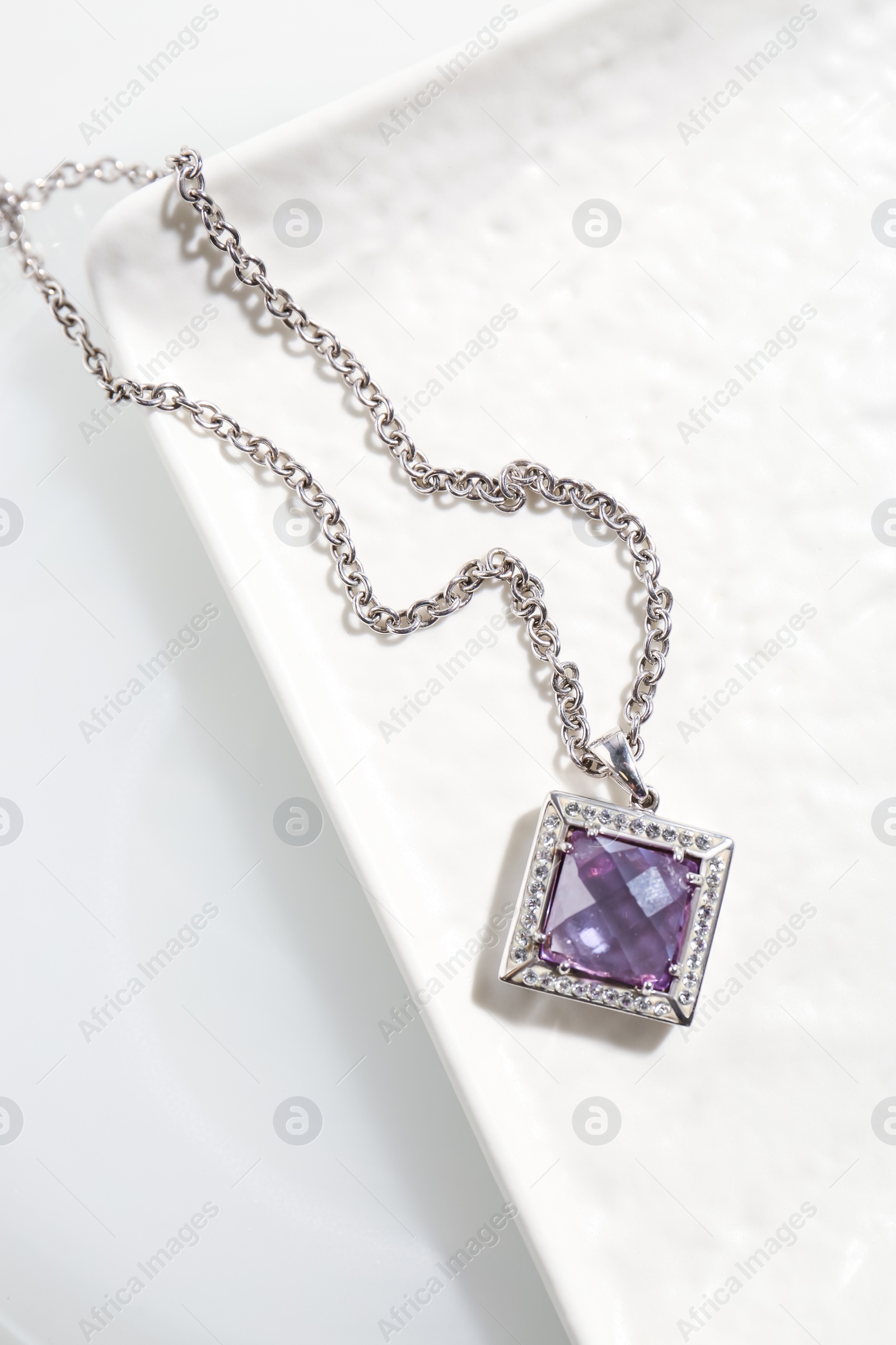 Photo of Beautiful necklace with gemstone on white table, top view