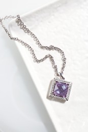 Photo of Beautiful necklace with gemstone on white table, top view
