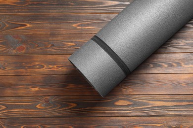 Photo of One yoga mat on wooden floor, top view