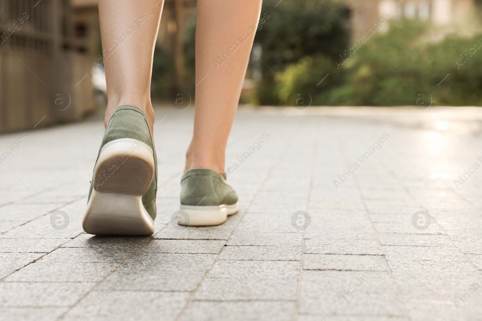 Photo of Woman in stylish loafers walking on city street, closeup. Space for text