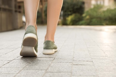 Photo of Woman in stylish loafers walking on city street, closeup. Space for text