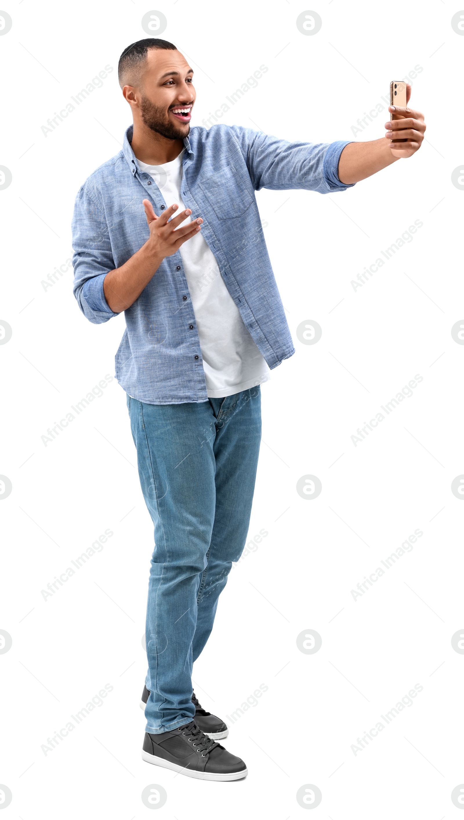 Photo of Smiling young man taking selfie with smartphone on white background