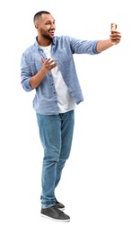 Photo of Smiling young man taking selfie with smartphone on white background