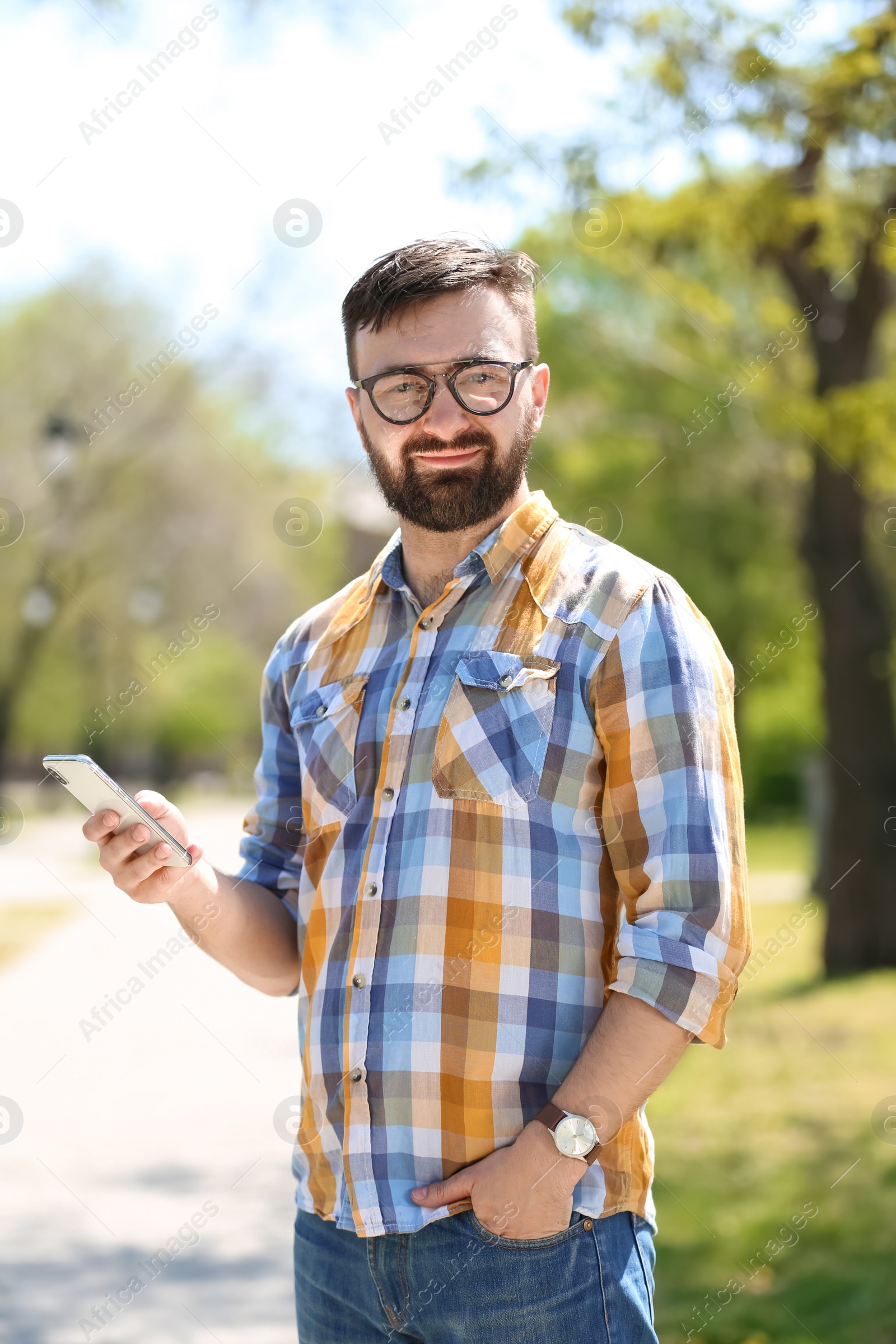 Photo of Portrait of young man with smartphone outdoors