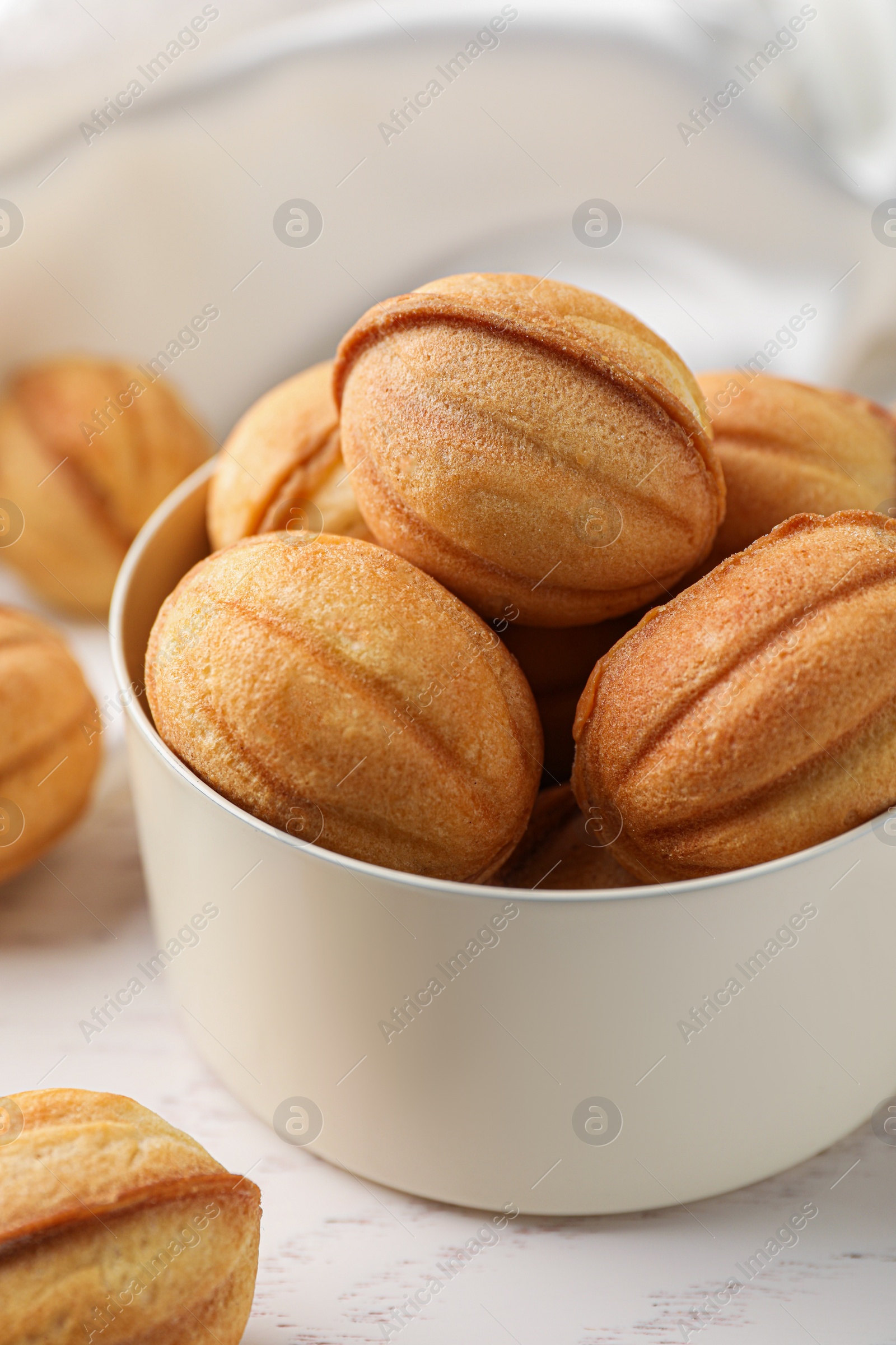 Photo of Delicious nut shaped cookies on white wooden table, closeup