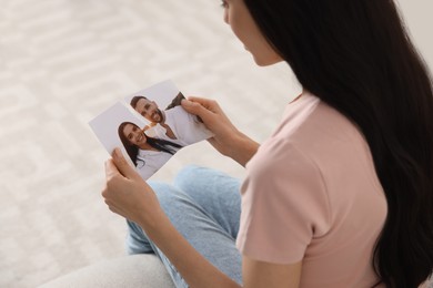 Photo of Woman holding torn photo at home, closeup. Divorce concept