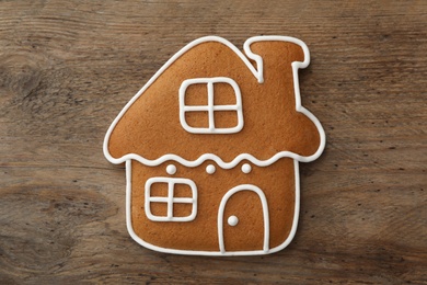 Photo of House shaped Christmas cookie on wooden table, top view