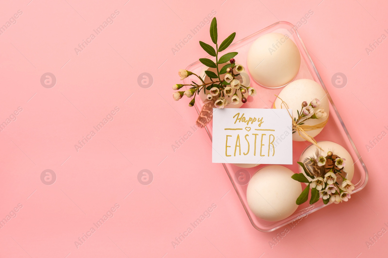 Photo of Flat lay composition with eggs, natural decor and phrase Happy Easter on pink background. Space for text