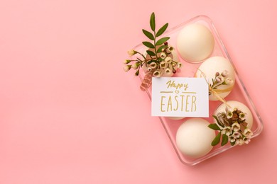 Photo of Flat lay composition with eggs, natural decor and phrase Happy Easter on pink background. Space for text