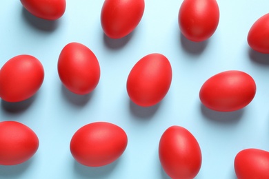 Flat lay composition of red dyed Easter eggs on color background