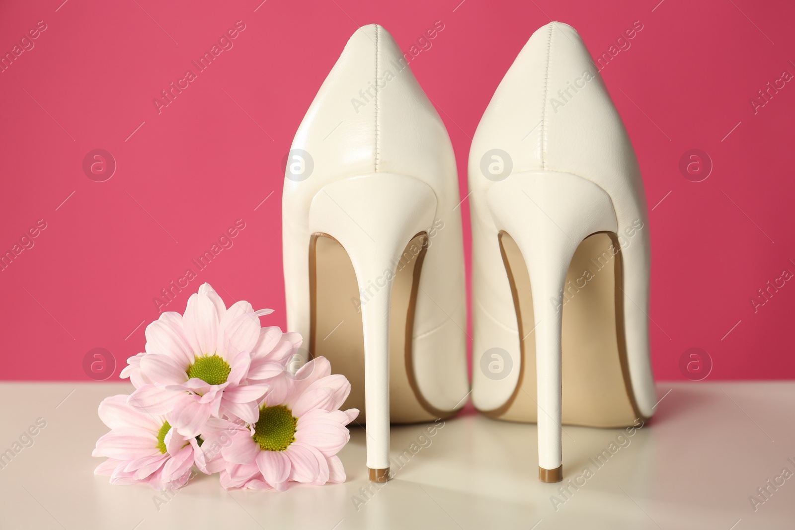 Photo of Beautiful tender flowers and woman's shoes on white table