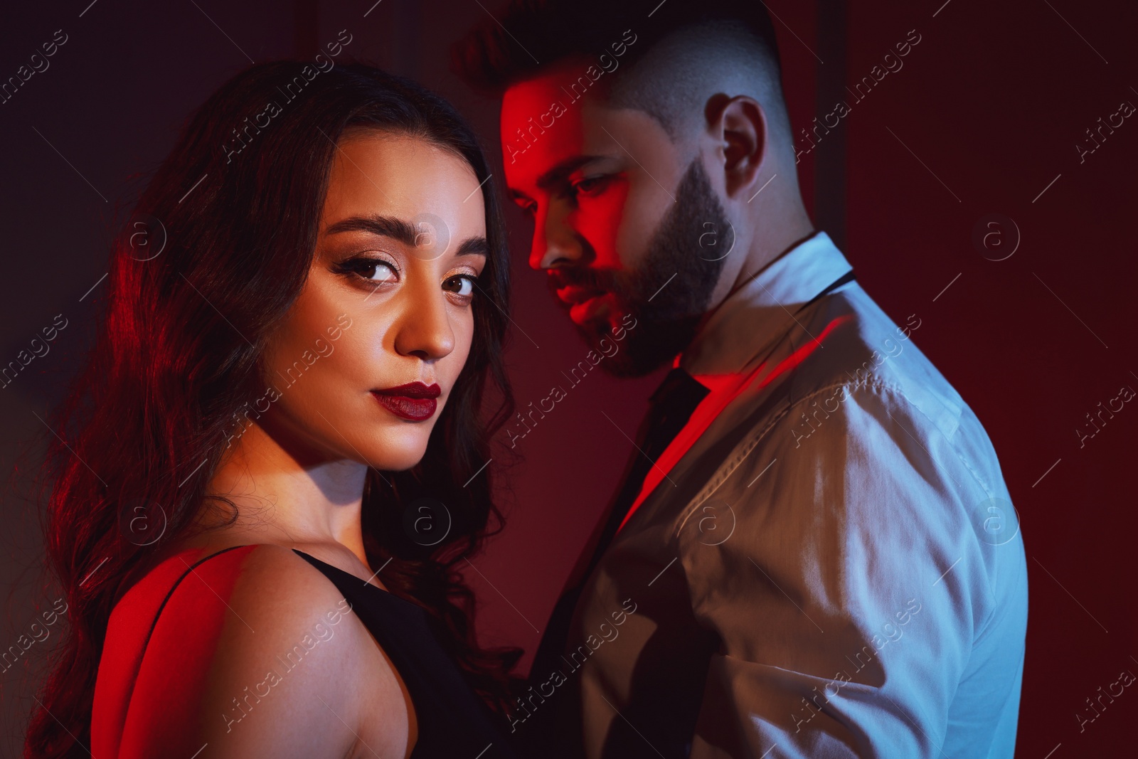 Photo of Handsome bearded man with sexy lady indoors. Color toned