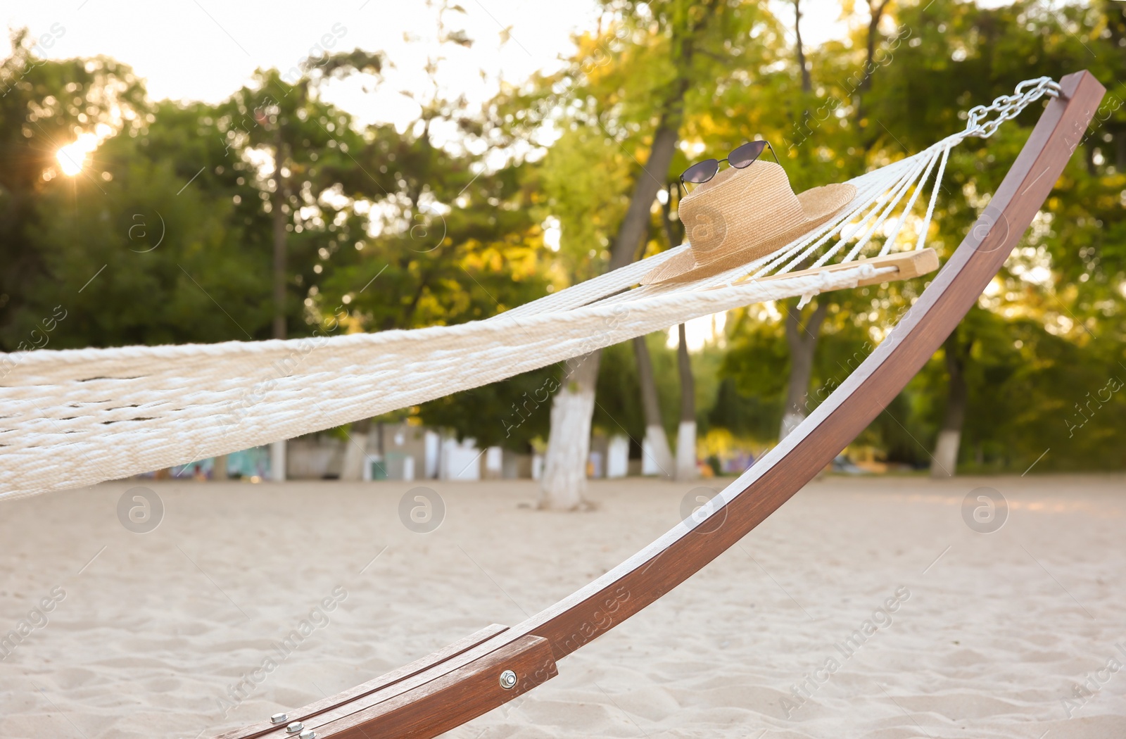 Photo of Comfortable hammock with straw hat and sunglasses at seaside