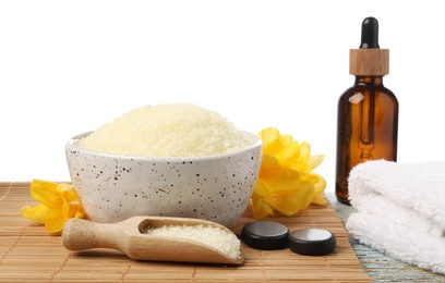 Photo of Natural sea salt in bowl and other spa supplies on wooden table against white background