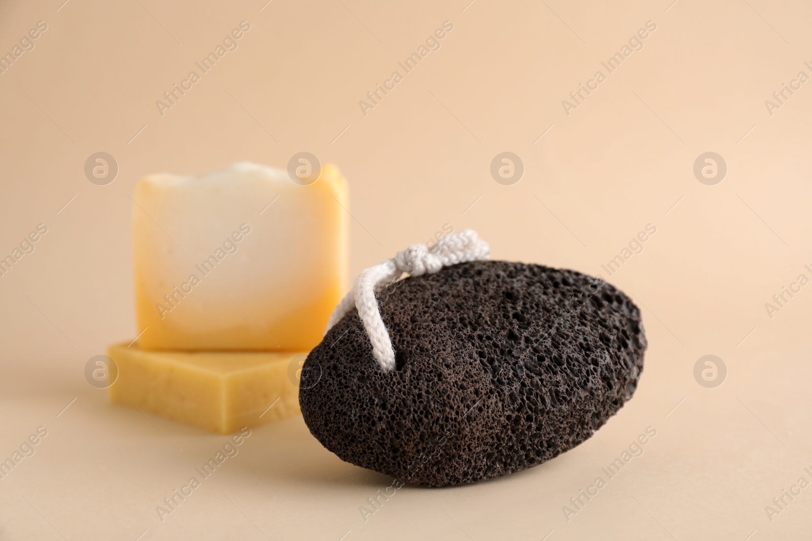 Photo of Pumice stone and soap bars on beige background