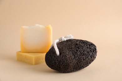 Photo of Pumice stone and soap bars on beige background