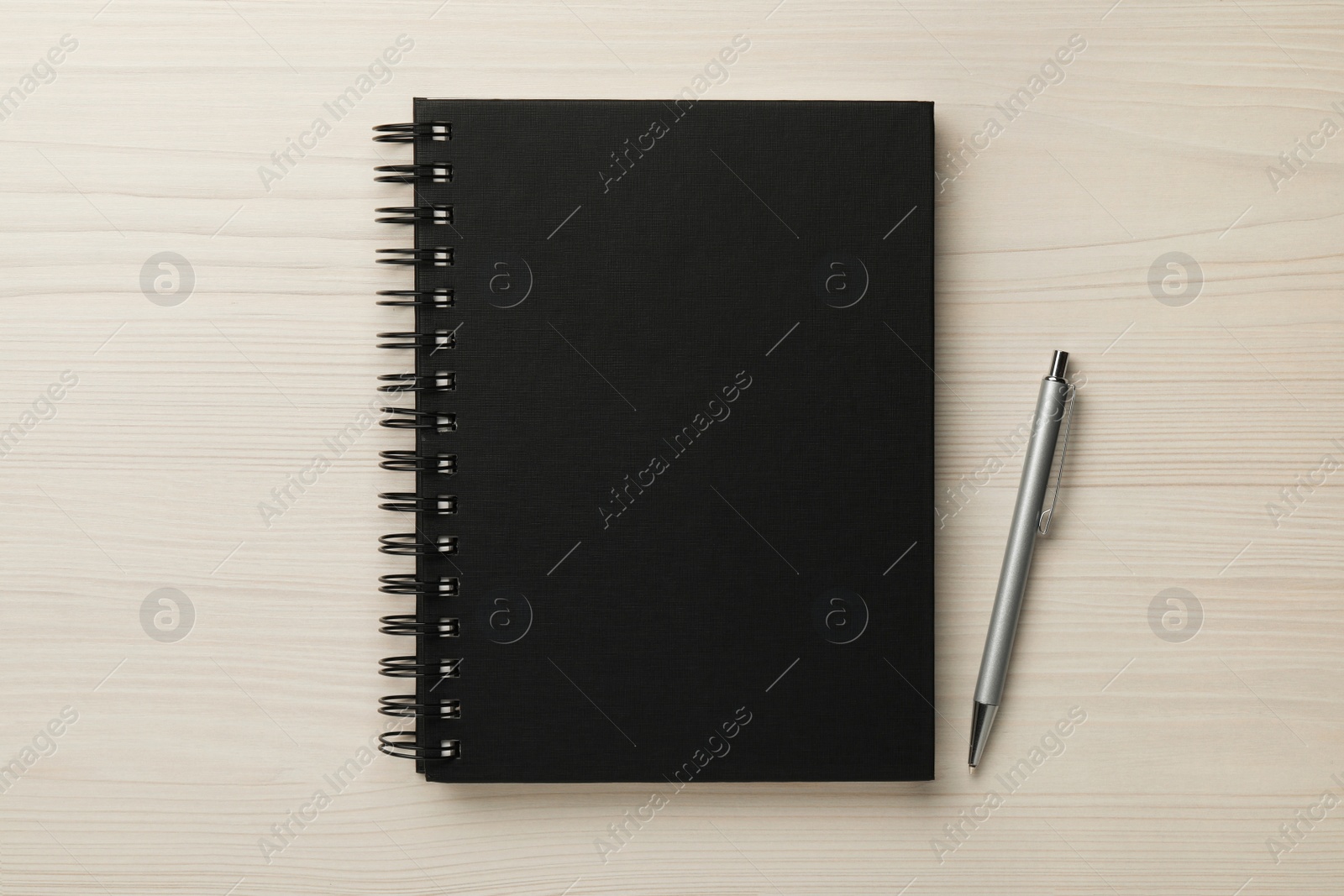 Photo of Notebook and pen on white wooden table, flat lay